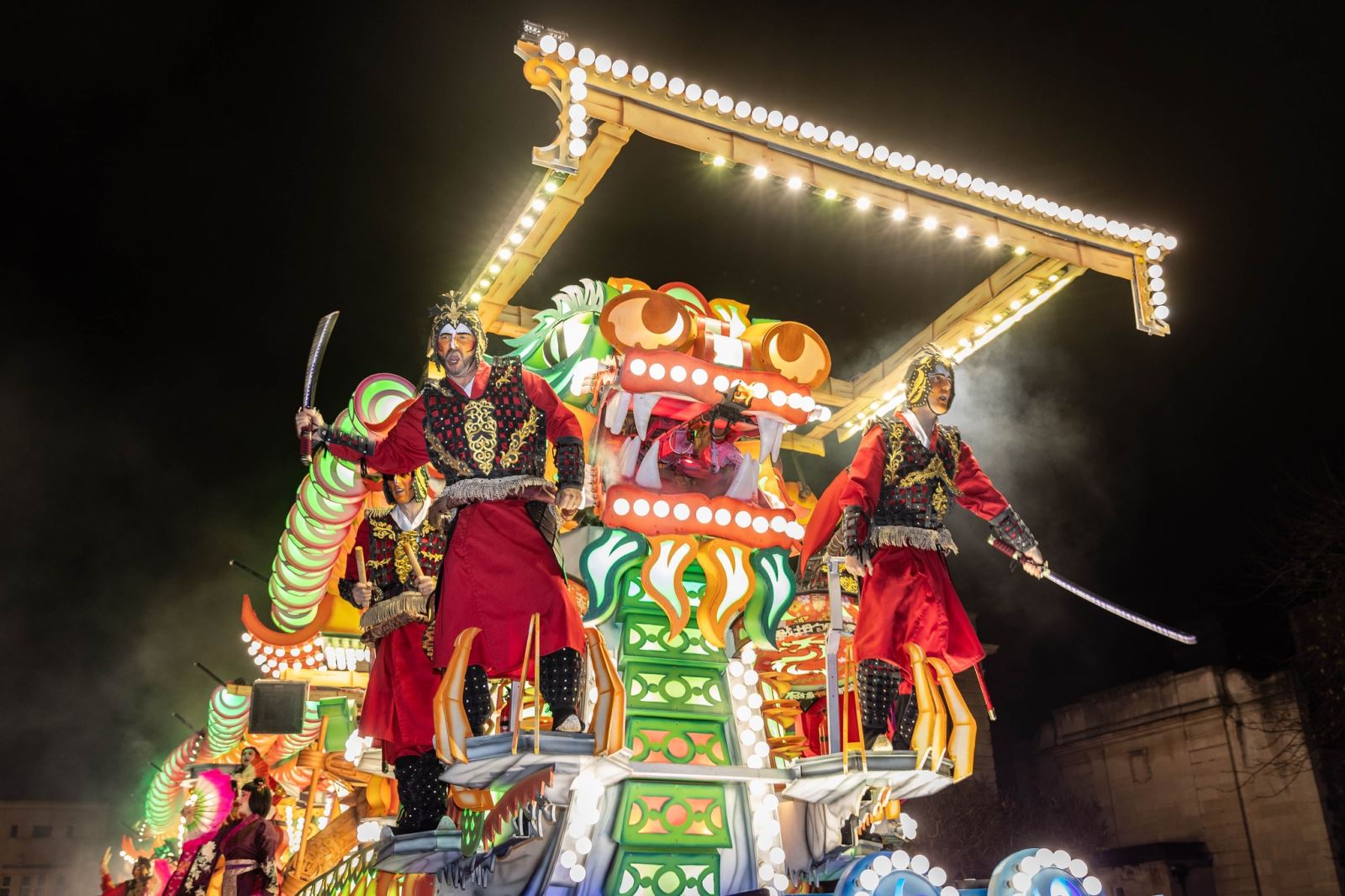 Ancient soldiers in red outfits and brandishing swords on a cart at the Weston-super-Mare Carnival